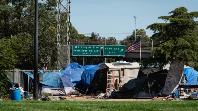 Encampment of unhoused people in Sacramento, California with freeway in the background