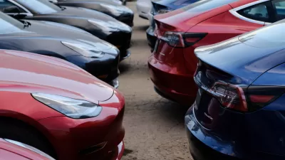 Close-up of multiple black and red Tesla cars parked in a lot