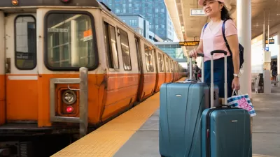 Orange Line platform with woman waiting with suitcases, Boston, Massachusetts