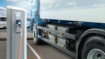 Concept rendering of white electric big rig truck plugged into charging station