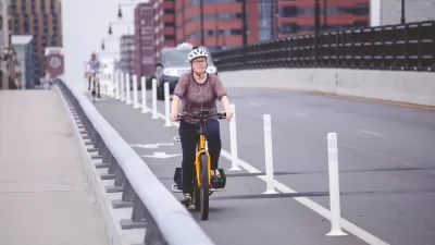Woman on bicycle in protected bike lane on Boston bridge
