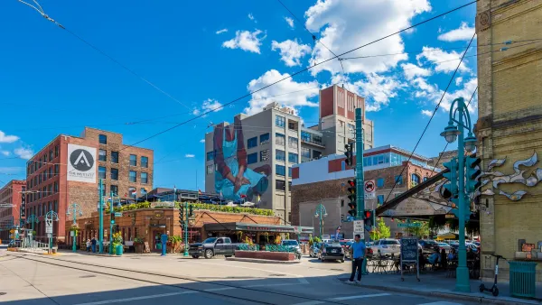 Intersection with murals on brick buildings and streetcar overhead wires in Milwaukee, Wisconsin on a sunny day.