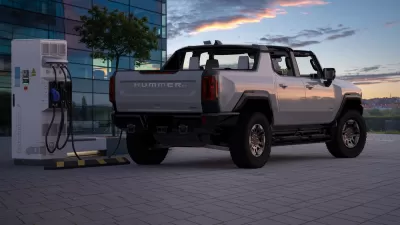 Rendering of grey convertible electric Hummer charging at a charging station against a sunset sky