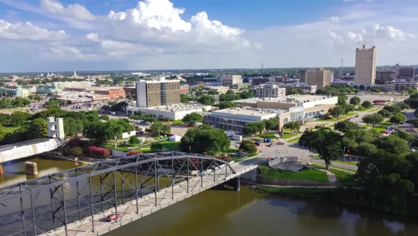 Aerial view of downtown Waco, Texas with river and bridge in foreground.