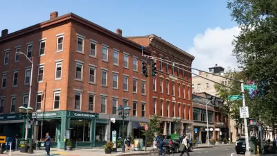 Crosswalk with pedestrians in front of four-story red brick buildings in New Haven, Connecticut