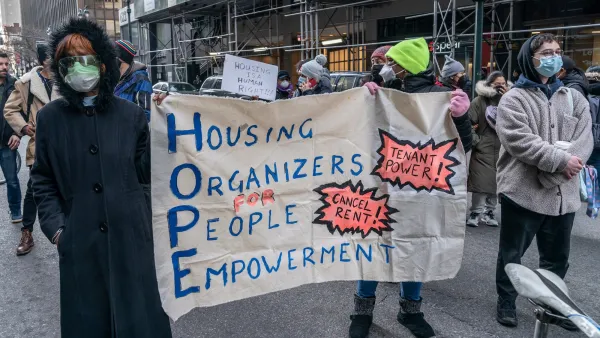 People wearing K95 masks holding a banner calling for renters' rights in a protest in New York City.