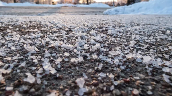 CLose-up of road salt sprinkled on roadway in winter.