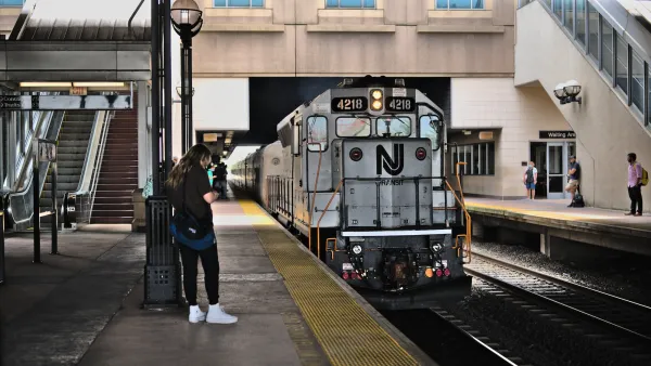Silver NJ Transit train pulling into a station.