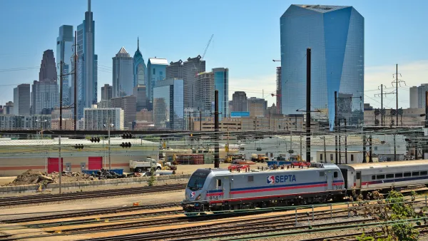 SEPTA train on track in front of Phildelphia city skyline.
