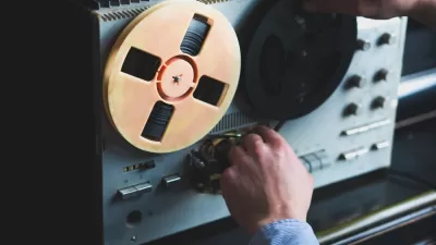 Close-up of reel-to-reel tape recorder with hand turning knob