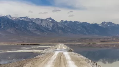 Unpaved road through Owens Lake bed with Sierra Nevada mountains in the background