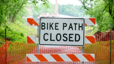 "Bike path closed" sign on orange and white construction barrier