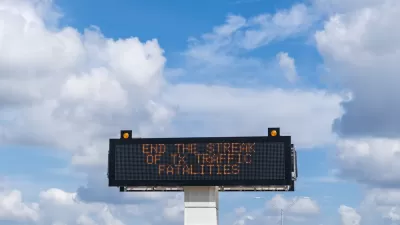Highway sign with "Stop the strak of TX traffic fatalities" against blue sky