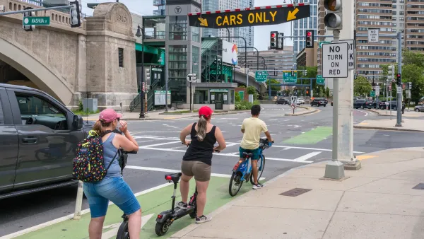 Two scooters and a bike ride in a bike lane in Boston