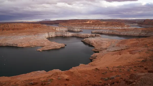 Lake Powell surrounded by red rocks with low water level.