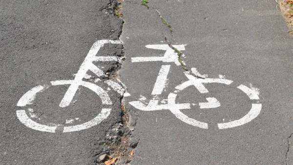 White bike logo on cracked asphalt.