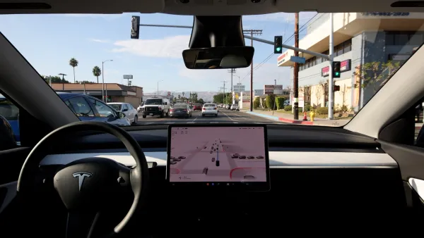 Interior dashboard of Tesla with large screen in middle.