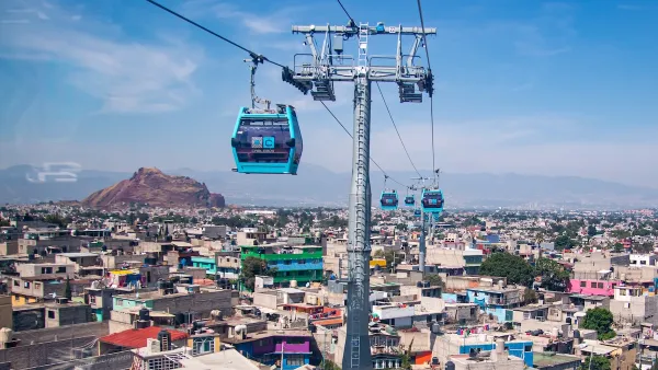 Blue aerial gondolas over colorful Mexico City neighborhood.