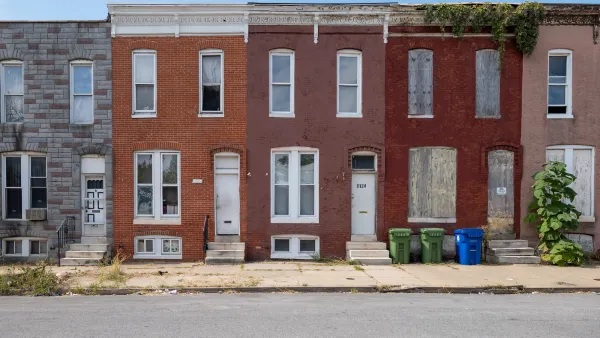 Vacant, boarded-up two-story urban homes in Baltimore, Maryland.