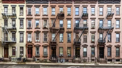 Multicolored four-story brick New York City apartment buildings with fire escapes