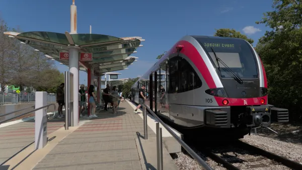 Red and silver light rail train pulling out of station in Austin, Texas.