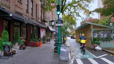 Green painted bike lane in New York City between sidewalk and outdoor dining kiosks
