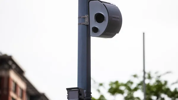 White traffic camera mounted on a pole.