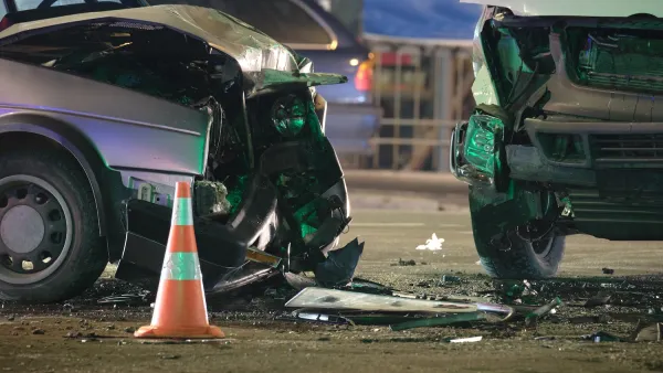 Two cars with smashed fronts stopped in street after crash.