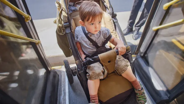 Boy in stroller being pushed onto bus.