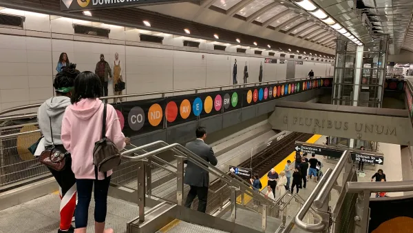 Two young women prepare to step onto the escalator to the lower subway platform of New York City's Second Avenue Line.