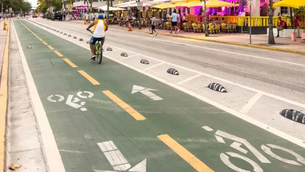 Man riding bike in green painted and protected bike lane in Miami, Florida.