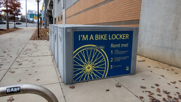 WMATA bike lockers on sidewalk at Tysons Corner, Virginia with large stickers on sides saying "I'm a Bike Locker - Rent Me" with information.
