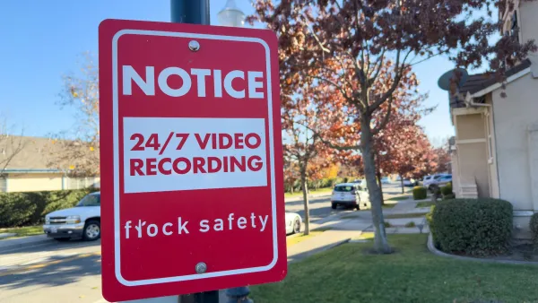 Red and white sign on post with "Notice: 24/7 video recording - Flock Safety" text.