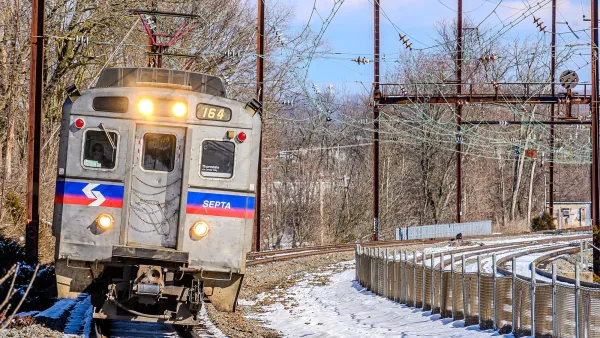 A silver SEPTA train passing through snowy scenery in Pennsylvania.
