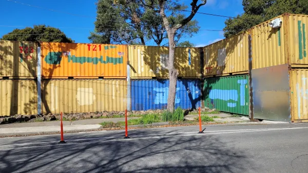 Colored shopping containers stacked two-high as a wall closing off People's Park in Berkeley, California.