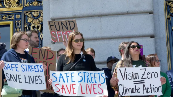 Traffic safety advocates holding signs calling for Vision Zero on steps of government building in San Francisco.