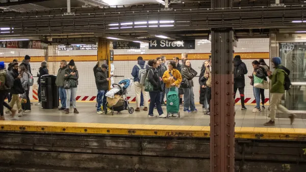 Crowd of people waiting on an NYC subway platform.