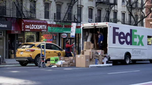 FedEx delivery truck with brown boxes stacked up behind it and yellow NYC van cab stopped at curb on NYC street.