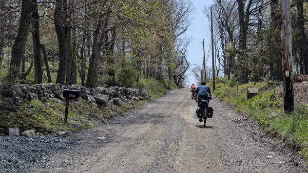 Two people on loaded touring bicycles on gravel Albany Post Old Trail.