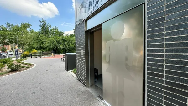 Modern public restroom with silver door in park in New York City.