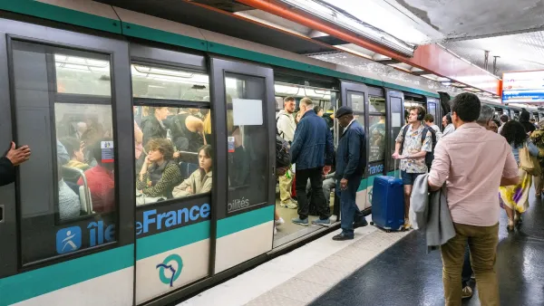 People boarding a train on a crowded Paris subway platform.