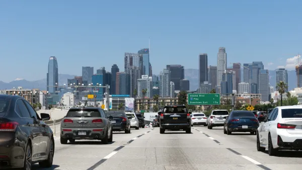 Traffic on a freeway heading into downtown Los Angeles on a sunny day.