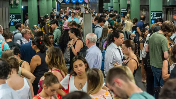 A crowded subway platform in NYC on a hot day