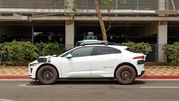White Waymo robotaxi parked next to red curb in Santa Monica, California.