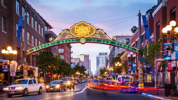 Neon sign over street for historic Gaslamp Quarter district of San Diego, CA at dusk.