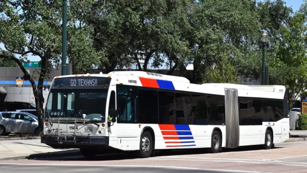 White articulated transit bus with blue and red stripes in Houston, Texas.