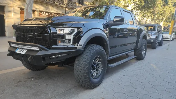 Black Ford F-150 Shelby Raptor Baja off-road pickup truck parked on Paseo de Gracia street in Barcelona.