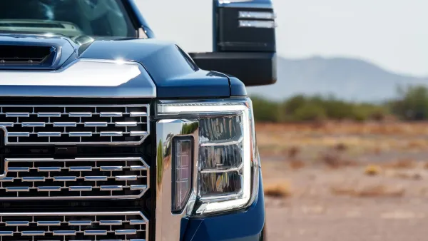 Close-up on silver grill of large blue pick-up truck.