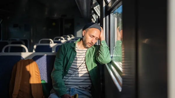 Tired man leaning on window sleeping on bus or tram.