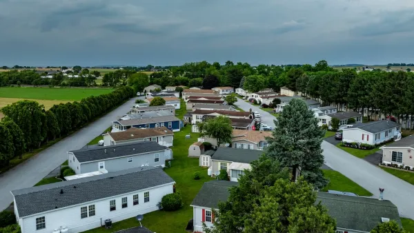 Home Park with many houses and trees. The houses are white and the trees are green. The sky is cloudy and the houses are spread out.